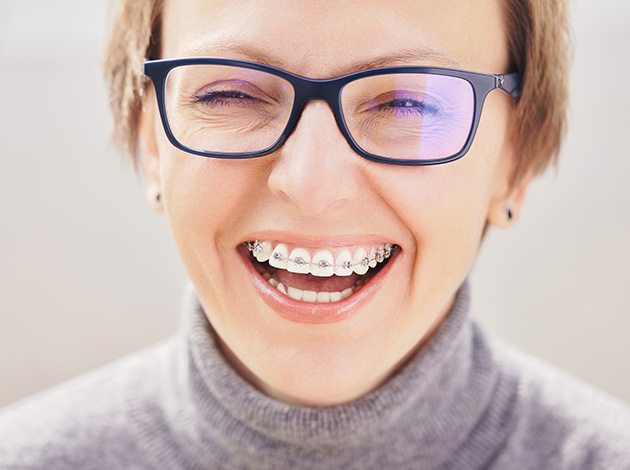 Adult female smiling with traditional braces