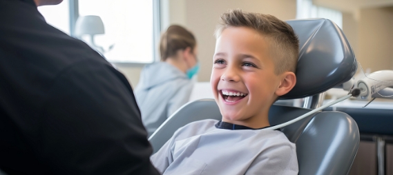 Young boy grinning in dental chair