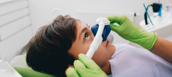 Young boy in dental chair wearing nose mask for nitrous oxide sedation