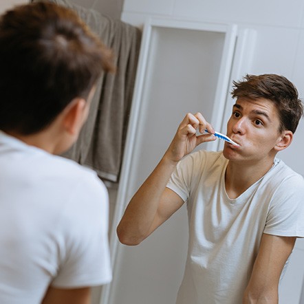 Teen brushing teeth in bathroom