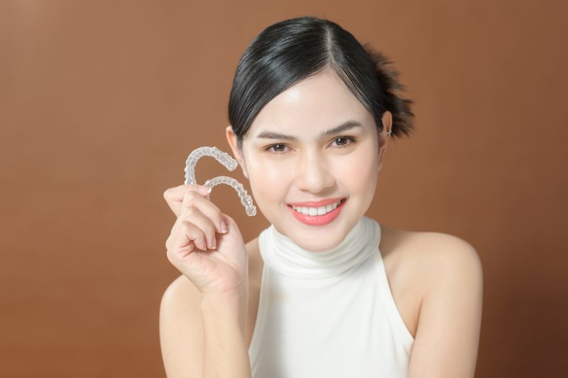 Teen smiles showing off Invisalign clear aligners